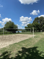 outdoor beach volleyball court near lake on sunny day