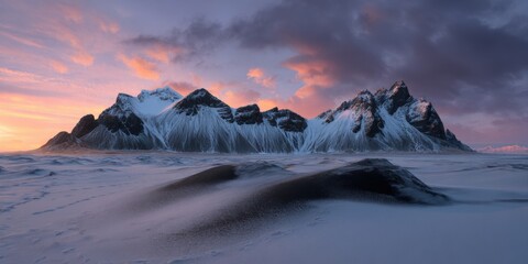 Majestic snow-covered mountains at sunrise with dramatic clouds and vibrant sky