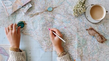 Individual sketching a personalized seaside adventure plan combining water sports and scenic route exploration.