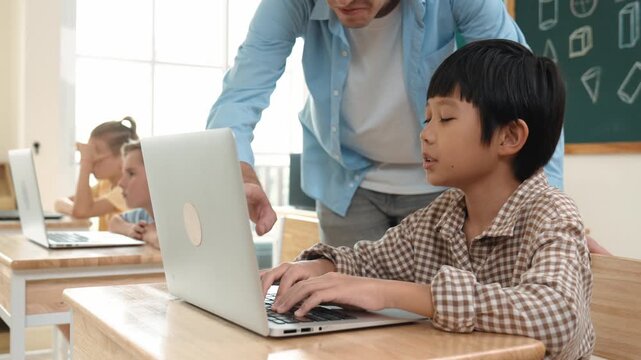 Caucasian teacher helping asian student coding engineering prompt while diverse student using software generated AI. Smart happy attractive children sitting and programing system. Education. Pedagogy.