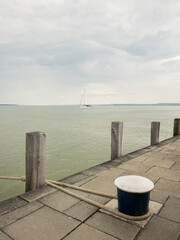 lake balaton sailboat view with mooring post and cloudy sky