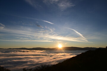 Stunning sunrise from a mountain top over the clouds