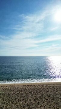 Aerial drone view, flying over the empty beach and blue sea water, vertical nature background
