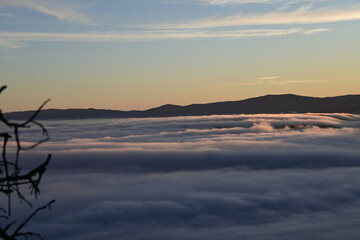 Stunning sunrise from a mountain top over the clouds