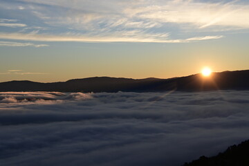 Stunning sunrise from a mountain top over the clouds