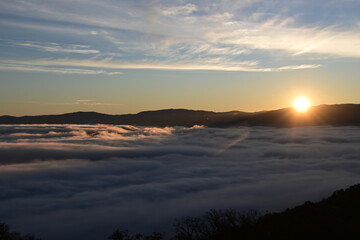 Stunning sunrise from a mountain top over the clouds