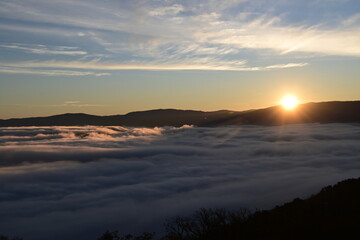 Stunning sunrise from a mountain top over the clouds