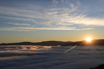 Stunning sunrise from a mountain top over the clouds