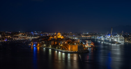 Obraz premium View of the Grand Harbour with Birgu and Cospicua, two of the Three Cities, featuring pleasure yachts, sailing boats during twilight in Valletta, Malta, 7 DEC 2025.