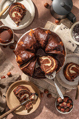 Chocolate marble bundt cake or zebra cake with chocolate glaze sliced on brown table background top view