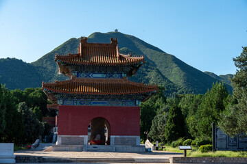Obraz premium The Stele Pavilion at the Ming Tombs Sacred Way with a green mountain peak in the background.