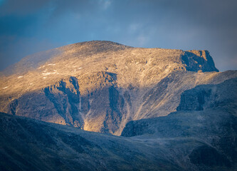 Rocky mountain face illuminated by low sunlight in Rondane