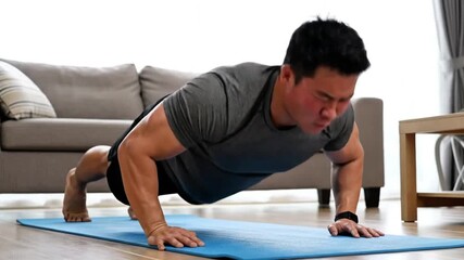 Man doing push-ups on a blue yoga mat in a living room