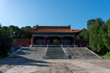 Fototapeta premium Frontal view of the majestic red Ling'en Gate approached by a wide stone staircase in Beijing.