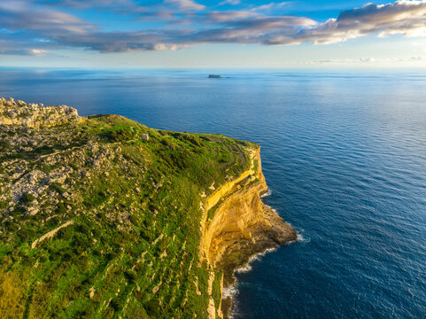 Drone view of cliffs and sea. Sunset, countryside, rocks. Filfla island and Dingli cliffs. Mediterranean sea, Malta