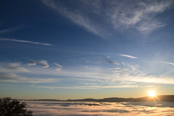 Fototapeta premium Stunning sunrise from a mountain top over the clouds