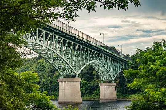 Memorial Bridge crosses the Kennebec River in Augusta, Maine, surrounded by lush greenery