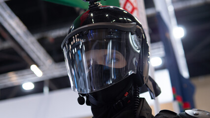 Responder wearing full face shield closeup showing clear visor, visible eyes, helmet and protective collar in exhibition setting with clinical lighting and confident professional expression