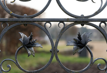 Forged decorative flowers on an antique iron fence
