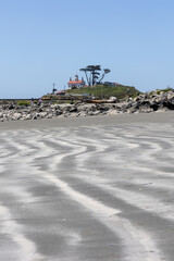 Natural sand patterns with Crescent City lighthouse in the distance