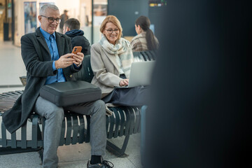 Mature couple enjoying digital connectivity in modern public space