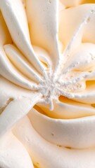 Close-up view of creamy, soft vanilla frosting with intricate swirls and smooth texture, perfect for dessert.