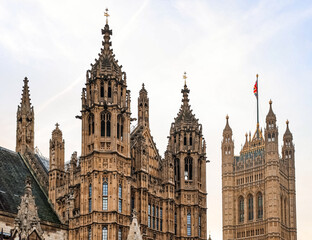 Fototapeta premium Palace of Westminster and Victoria Tower details in London, showing intricate gothic architecture and UK flag