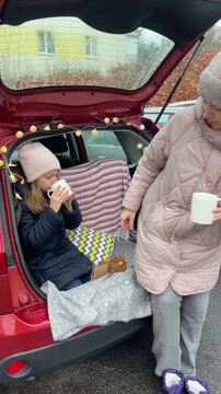 Enjoying a Cozy Car Picnic with Mother and Daughter during Winter Season