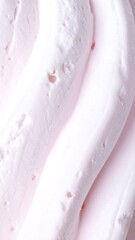 A close-up, abstract view of soft, light pink, wavy cream or frosting texture.