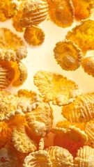 Close-up view of numerous golden, crispy, textured food pieces scattered on a bright surface.