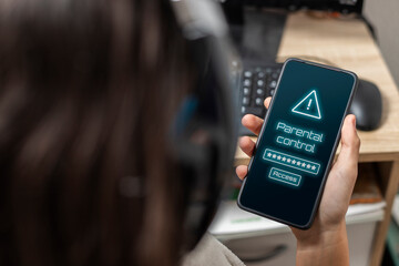 A teen holding a mobile with parental control warning