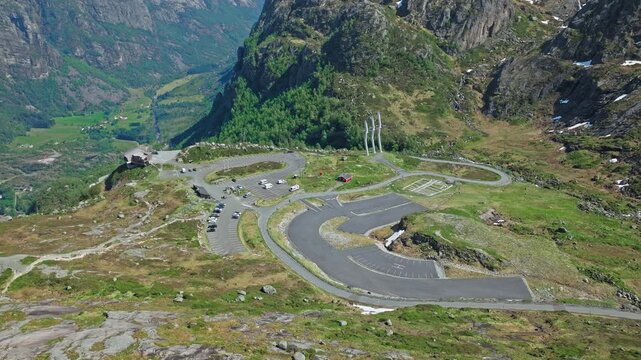 Drone flying above the Lysebotn hairpin road near Kjerag, Norway. Scenic mountain landscape reveals winding road curves, steep granite slopes and remote alpine nature in summer.