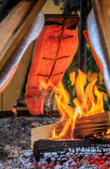 Flame grilled salmon cooks over wood fire, Zurich Christmas market, Switzerland