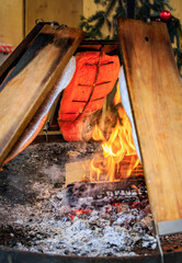 Flame grilled salmon cooks over wood fire, Zurich Christmas market, Switzerland