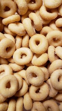 Close-up of crispy golden ring-shaped snacks covered in sugar or salt - Close-up de petiscos crocantes e dourados em formato de anel cobertos com a&ccedil;&uacute;car ou sal