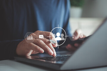 Business professional using laptop with virtual user targeting interface data icon, customer analytics, audience segmentation, digital marketing strategy, AI insight, data driven business decision.