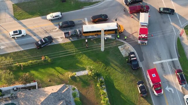 Traffic accident on street in Florida. First responders helping victims of school bus and car crash on road in USA. Aerial view of emergency services at accident site.