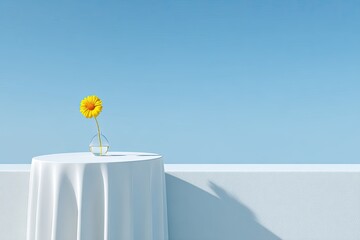 Single yellow gerbera in vase on draped table against a blue backdrop
