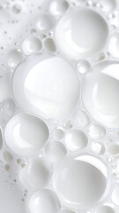 Close-up macro shot of white foam bubbles with reflections on a light surface.