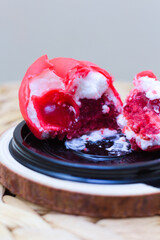 A luxurious glossy fruits shaped dessert with a mousse and berry filing, presented on a biscuit...