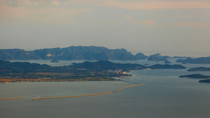 Amazing view from Langkawi's cable car: Majestic Gunung Machincang unfolds below, a tapestry of lush greenery and dramatic cliffs against azure skies.