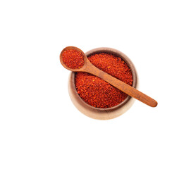 Ground or crushed organic annatto in the spoon and in the bowl - Bixa orellana
