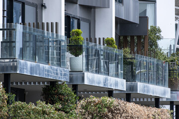 A row of modern townhouses featuring glass balcony balustrades and contemporary architecture. Medium-density residential living, and suburban townhouse housing in Australia.