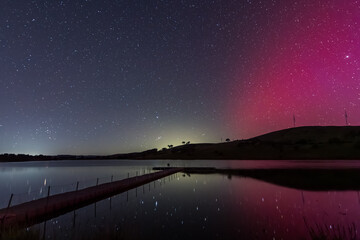 Aurora Australis display lights up the sky in pinks over the dam