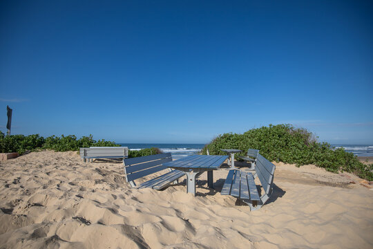 Tables and chairs at the beach buried in deep sand after storms in Australia