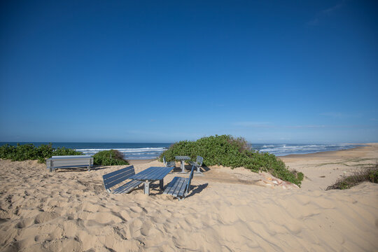 Blue skies over Birubi Beach after storms causing tables and chairs to be buried in sand