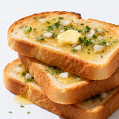 Close-up of crispy toasted bread slices topped with melted butter, minced garlic, and chopped parsley, served on a white plate.