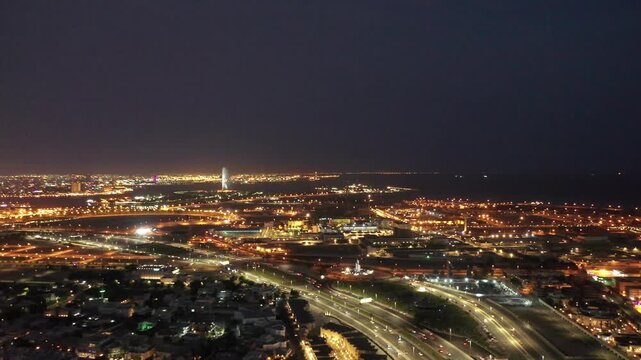 Aerial night view of King Abdulaziz Road and Jeddah city skyline with traffic