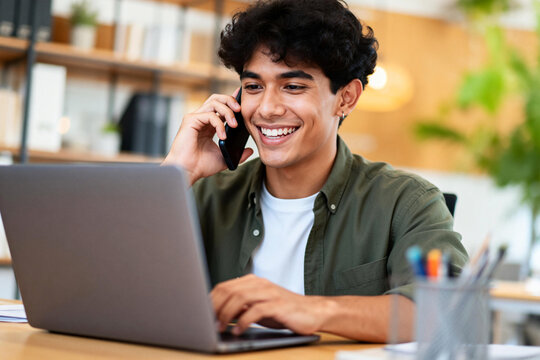 Smiling Young Professional on Phone and Laptop - Powered by Adobe