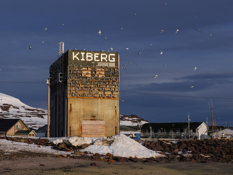 Old industrial concrete building with Kiberg sign under a stormy sky in the Arctic village of Kiberg, Norway kittiwake hotel